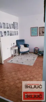 Manji dio dnevne sobe sa plavom foteljom i parketom na podu. - image 7