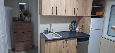 Small kitchen with wooden cabinets and a sink. - image 5