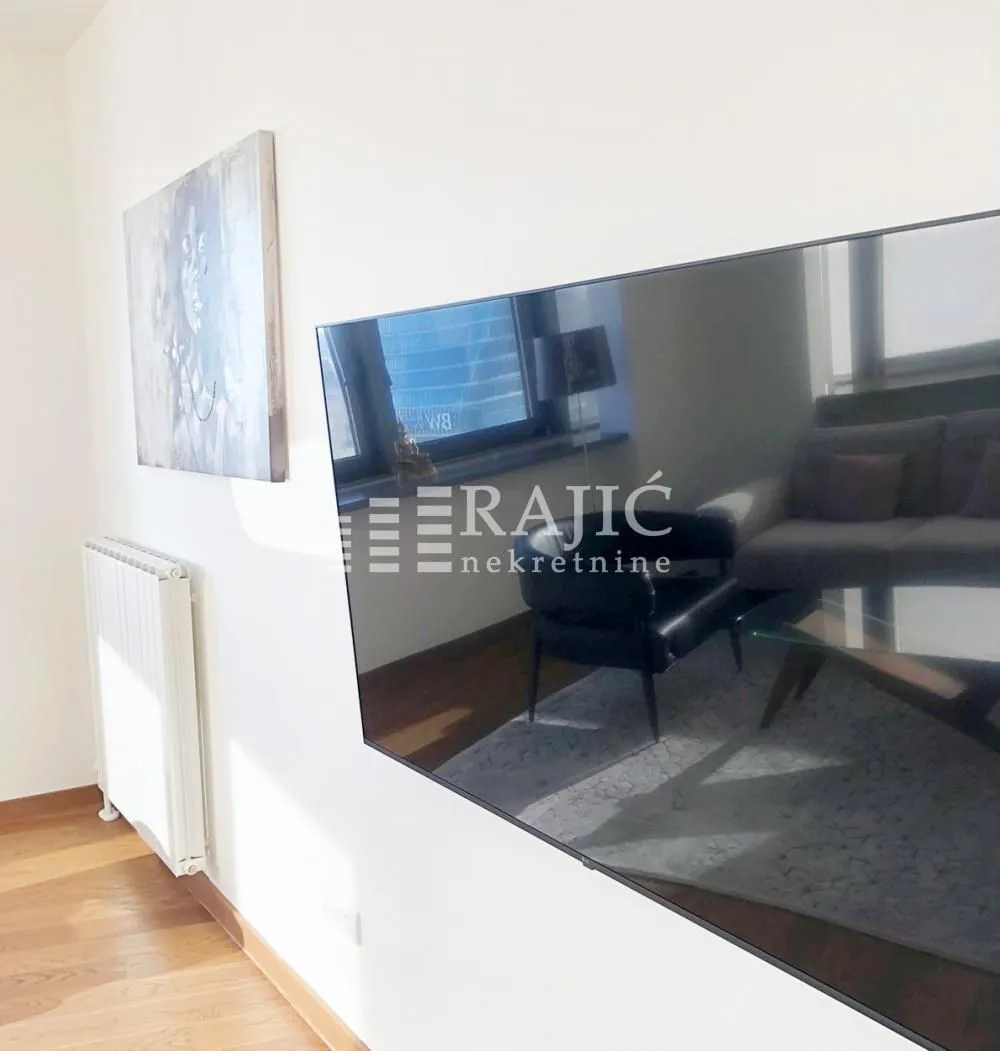 Living room with a large TV on the wall and an artwork.