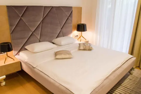 Moderna spavaća soba sa bračnim krevetom, tapaciranim uzglavljem i noćnim stočićima sa lampama. - image 31