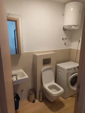 Small bathroom with sanitary fixtures, washing machine, and water heater. - image 7