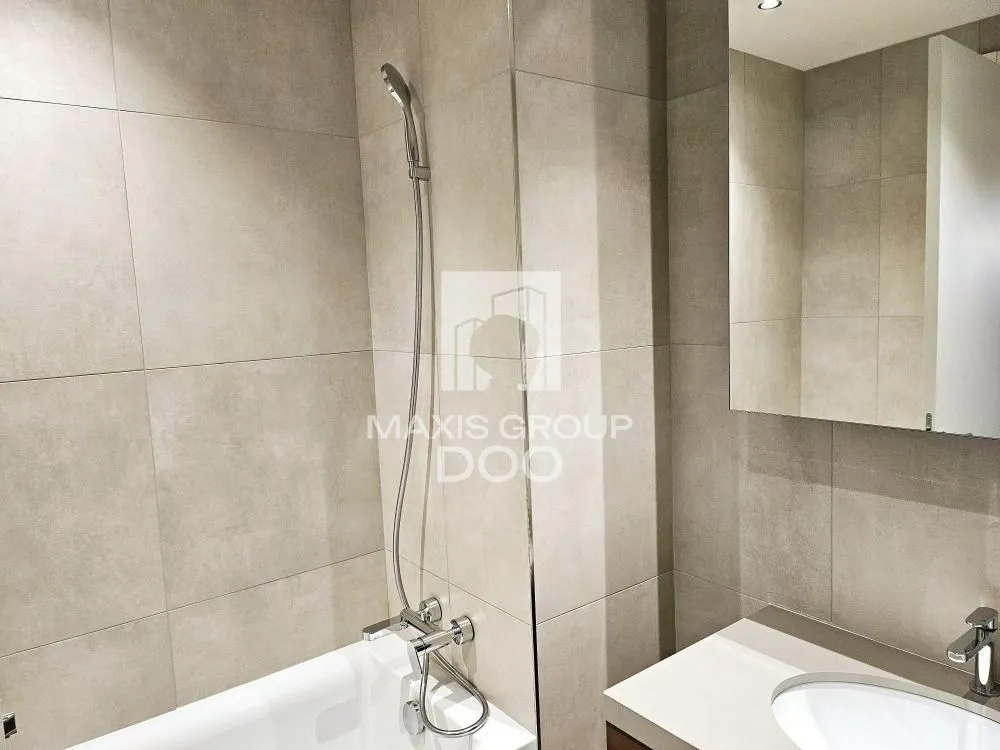 Modernly equipped bathroom with a bathtub and a washbasin.