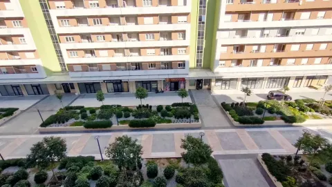 Pogled sa visine na uređeno dvorište i fasadu stambene zgrade. - image 4