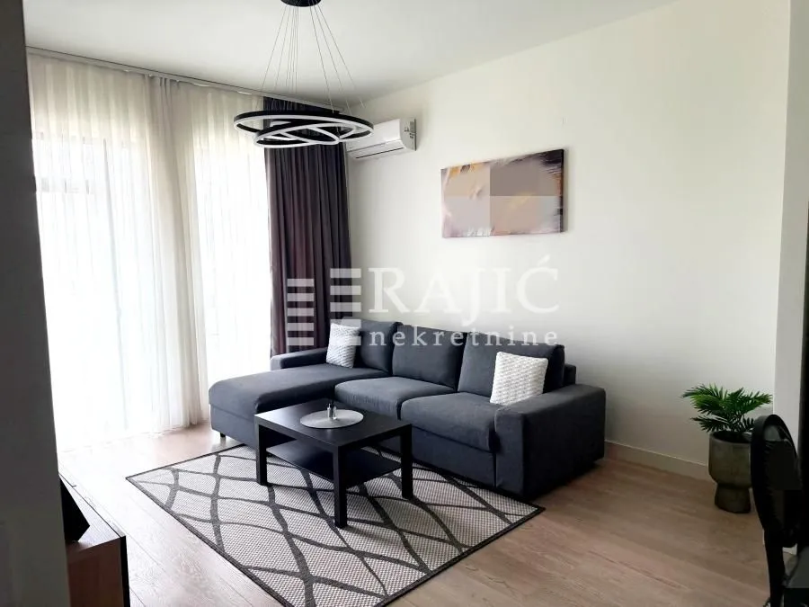 Living room with a sofa, coffee table, and large window.