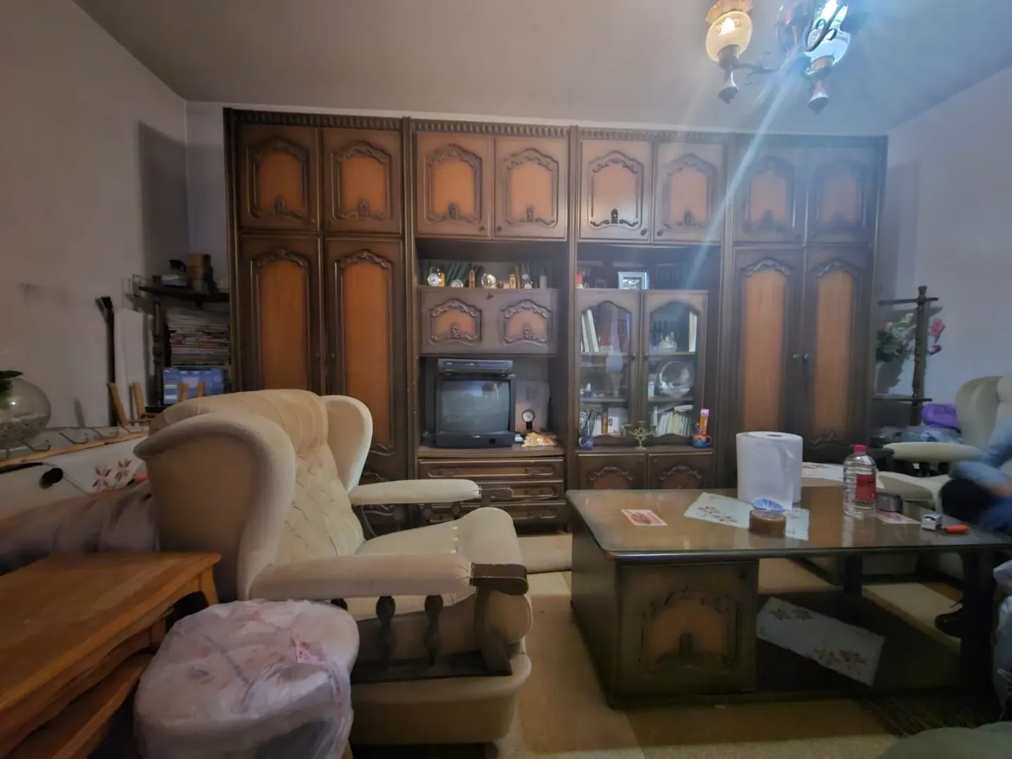 Dnevni boravak sa garniturom i velikim drvenim ormarom.