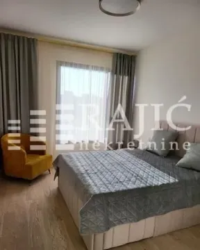 Furnished bedroom with a double bed, an armchair, and a window. - image 5