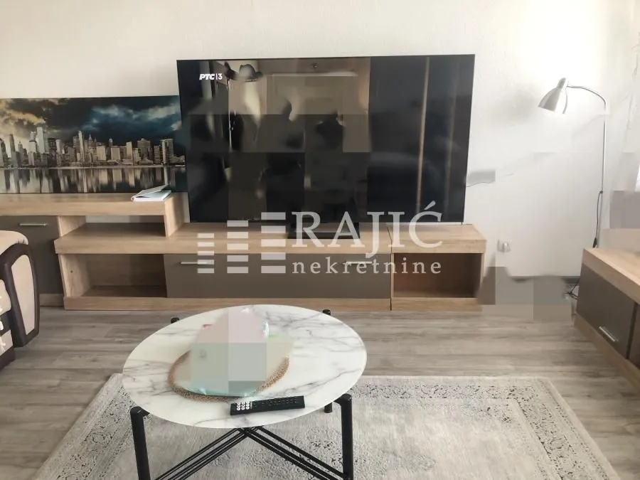 Living room with a sofa, TV, and coffee table.