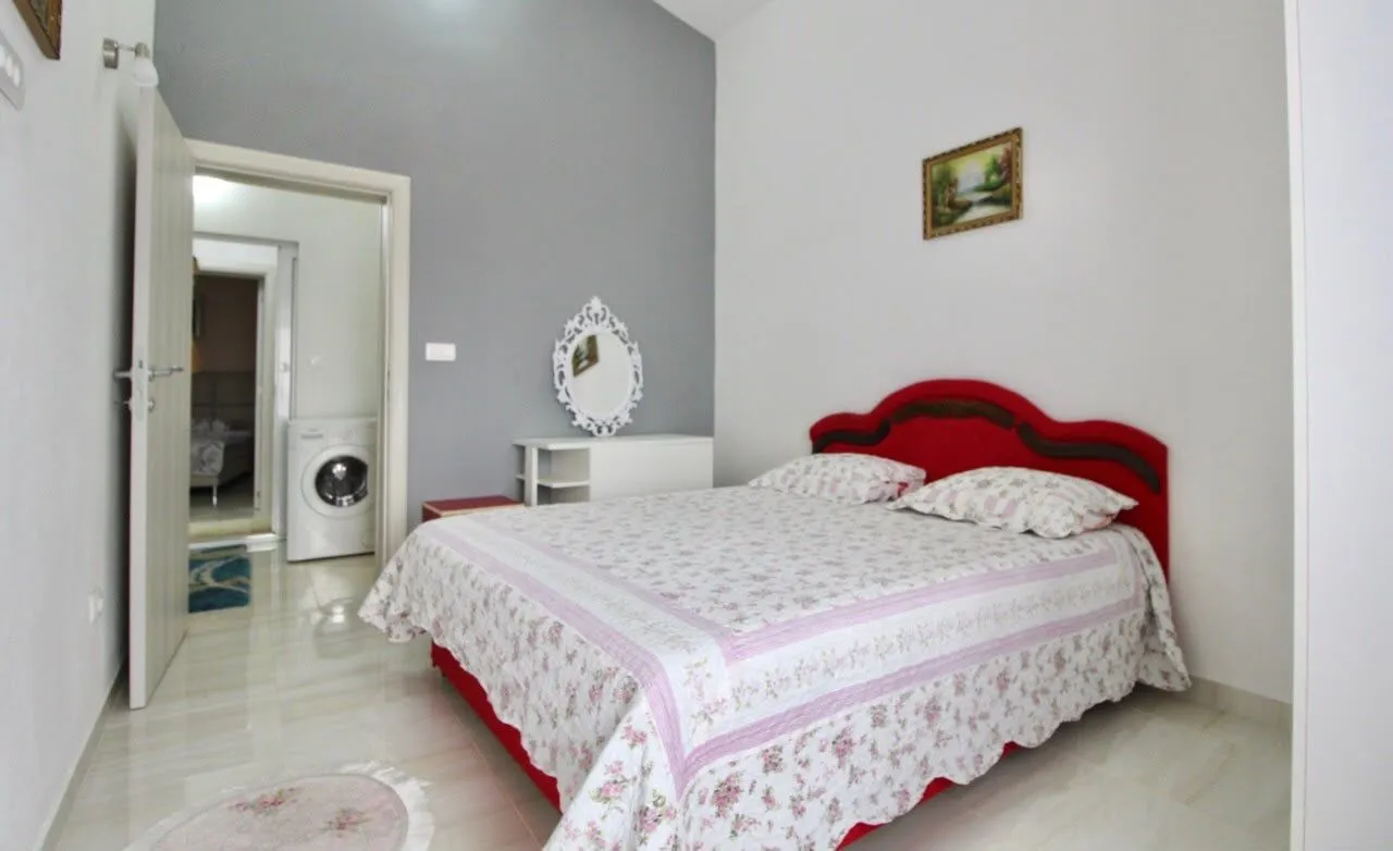 Bedroom with a double bed, mirror, and a view into the bathroom.