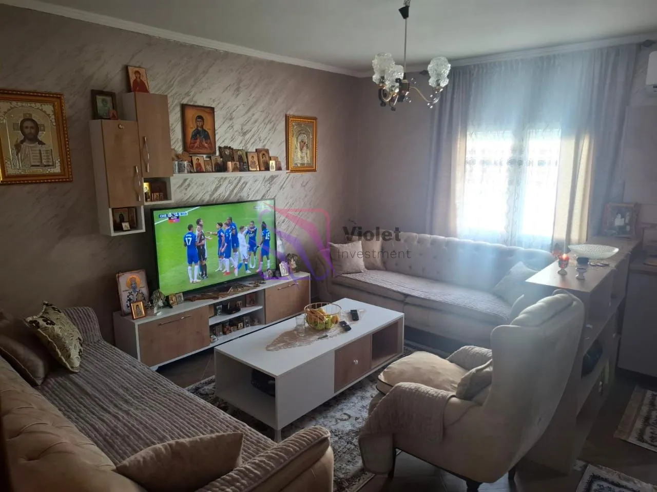 Living room with sofa set, coffee table, and television.