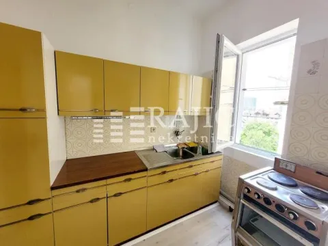 Smaller kitchen with yellow kitchen cabinets and an electric stove. - image 7