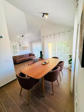 Living room with a dining table and a sofa. - image 14