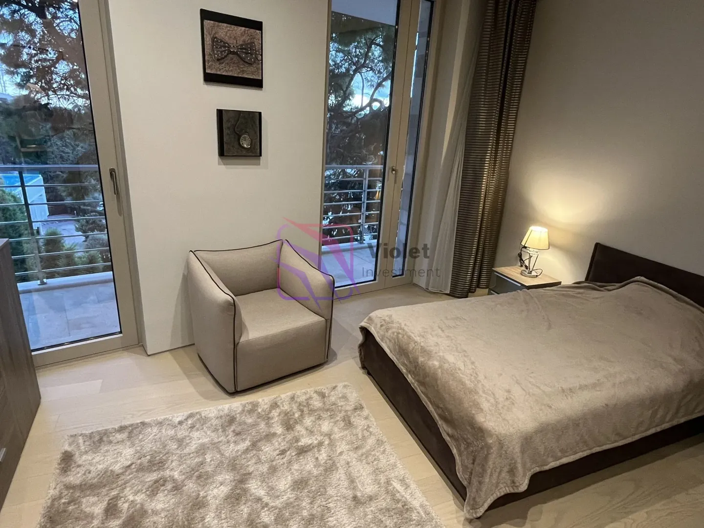 Furnished bedroom with a bed, armchair, and access to the terrace.