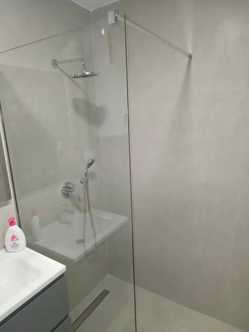 Moderne kupatilo sa tuš kabinom i umivaonikom.