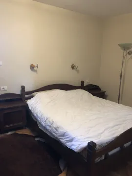 A bedroom featuring a wooden double bed and matching nightstands. - image 21