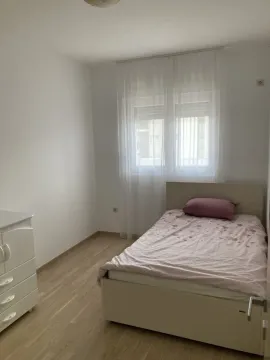 Bright and tidy bedroom with a bed and a dresser. - image 6