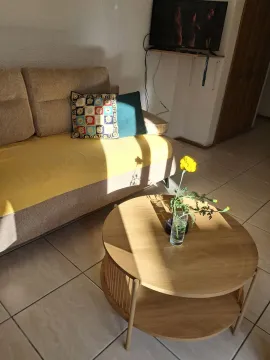Living room with a sofa and a wooden coffee table. - image 9