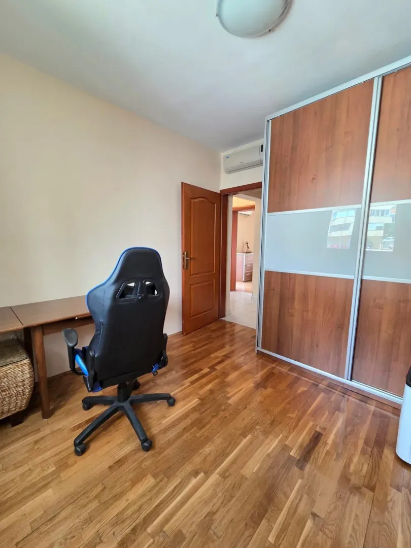 Manja soba sa drvenim podom, radnim stolom, stolicom i velikim ugradnim garderoberom.
