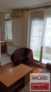 Dnevna soba sa foteljom, stočićem i izlazom na terasu. - image 5
