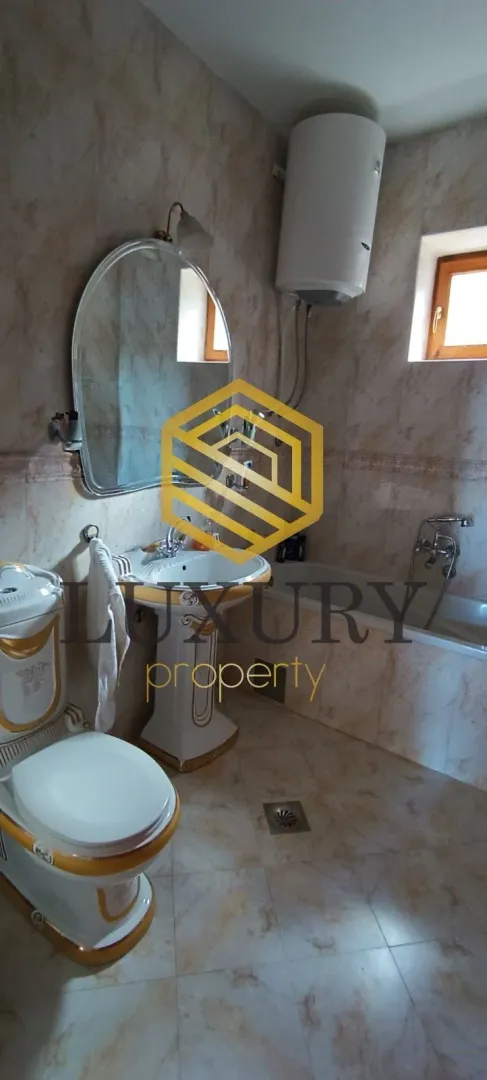 Small tiled bathroom with a bathtub and a sink.