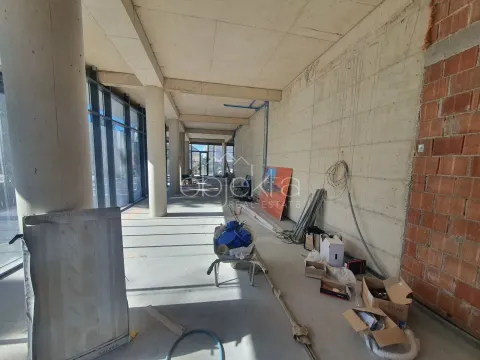 View of an unfurnished space under construction with concrete pillars and large windows. - image 6
