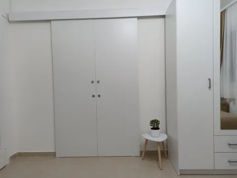 Bijeli ugradni plakari u sobi sa malim stočićem i saksijom. - image 14
