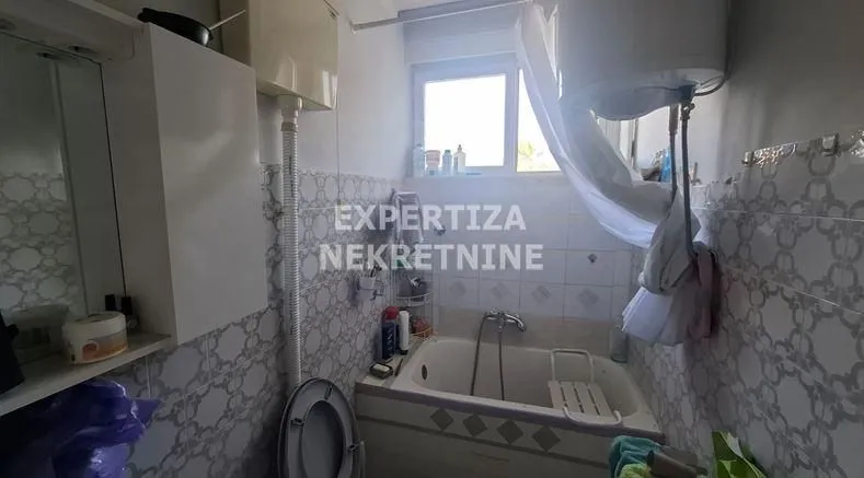 Manje kupatilo sa kadom i osnovnim sanitarijama.