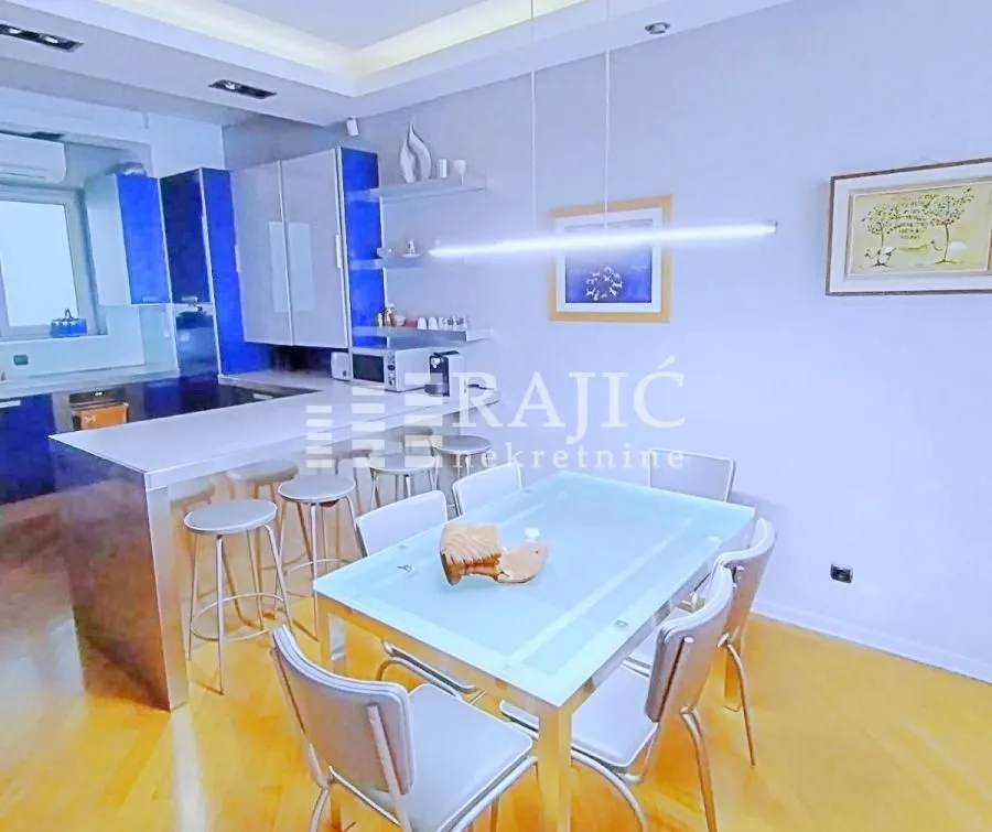 Modern kitchen with dining area and white cabinets.