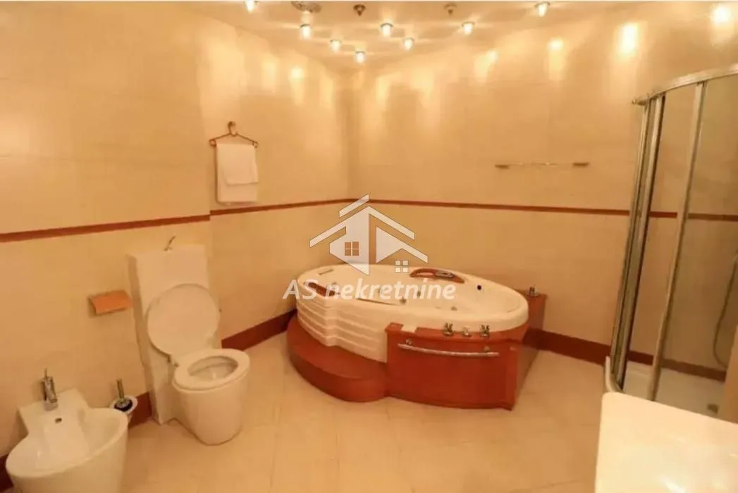 Bathroom equipped with a toilet, bidet, corner hydro-massage bathtub, and a shower cabin.