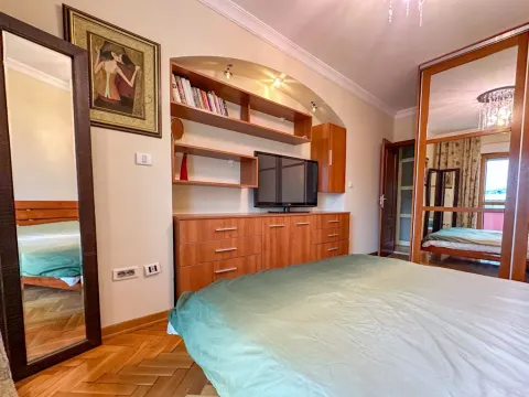 Furnished bedroom with a double bed, wooden wardrobe and a TV. - image 9