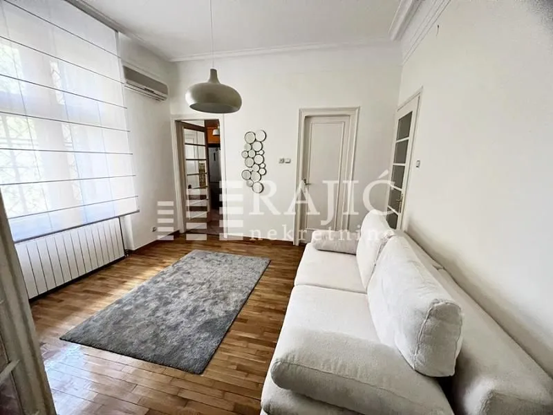 Living room with a sofa and parquet flooring.