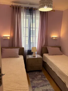Uređena spavaća soba sa dva odvojena kreveta i noćnim stočićem. - image 13