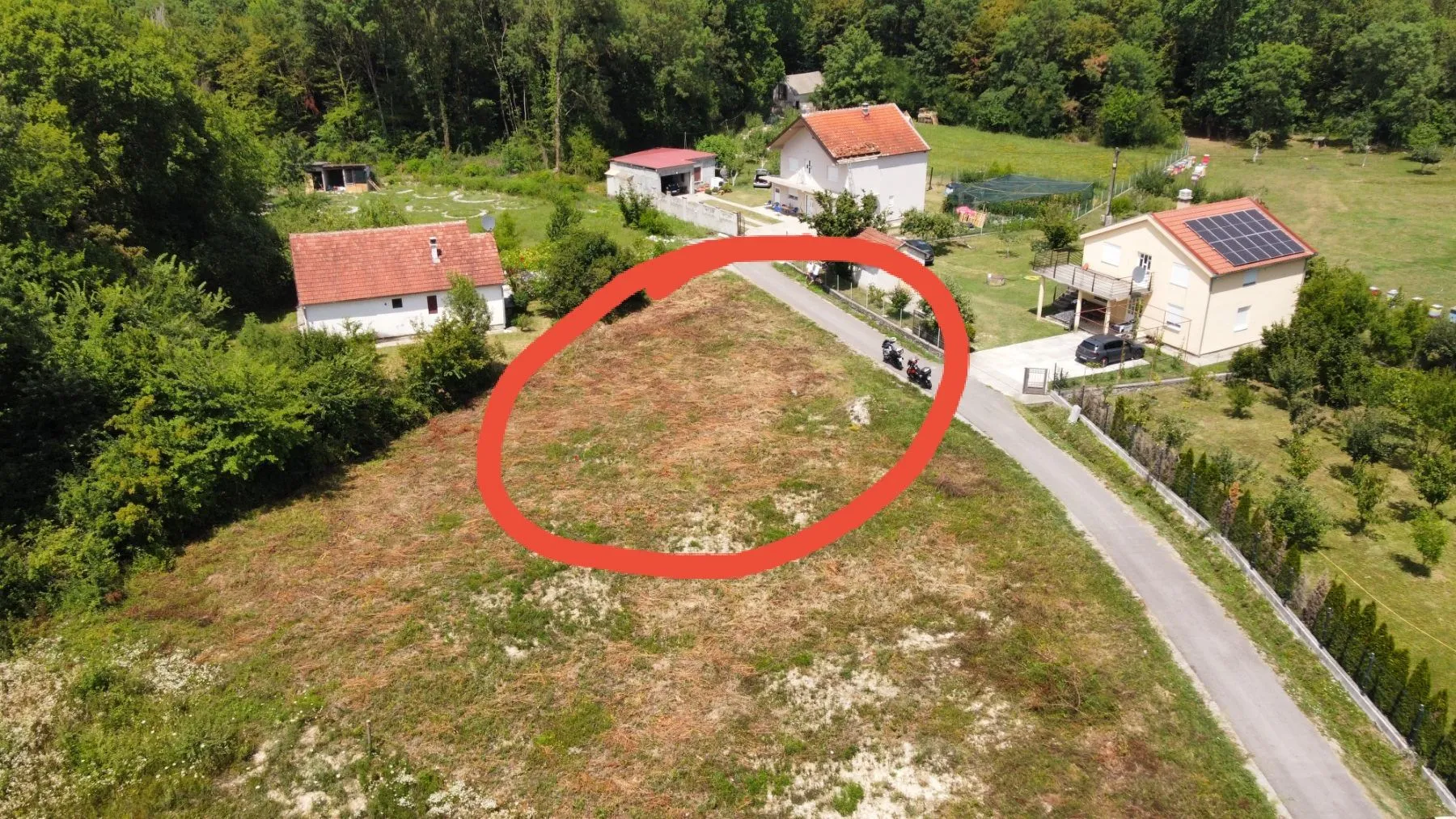Pogled iz vazduha na građevinsko zemljište sa okolnim kućama.