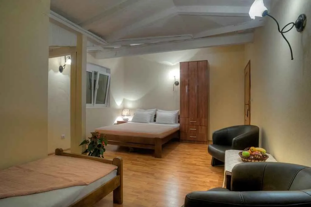 Uredna spavaća soba sa bračnim krevetom i foteljama.