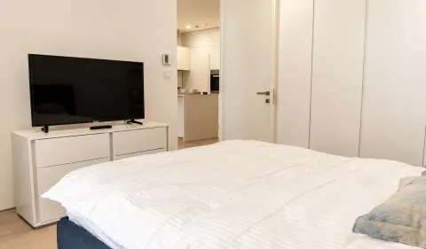 Moderna spavaća soba sa bračnim krevetom, komodom i televizorom. - image 4