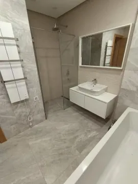 Modern bathroom with walk-in shower, bathtub, washbasin, and mirror. - image 18