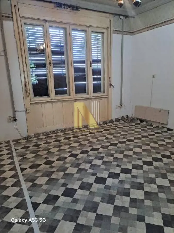 Empty room with a window and patterned flooring.