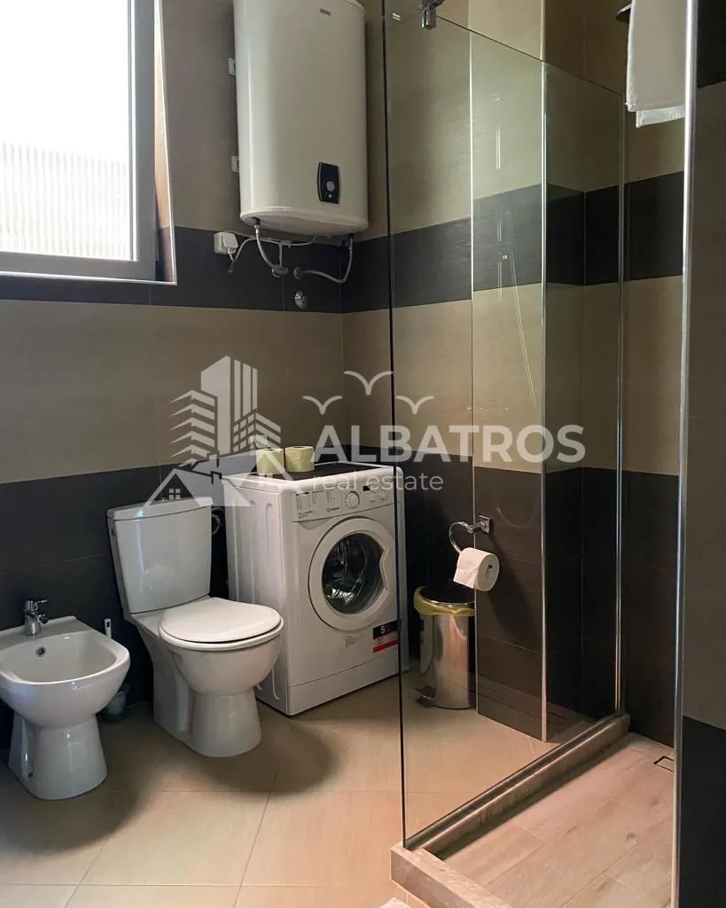 Bathroom equipped with sanitary fixtures, a shower cabin, and a washing machine.
