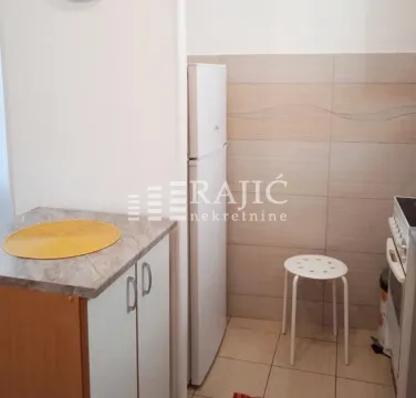 Small kitchen with a refrigerator and cabinets. - image 4