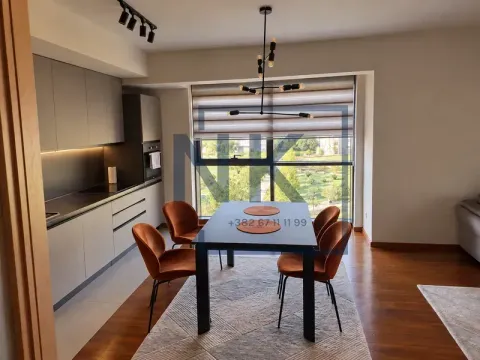 Open plan space featuring a kitchen, dining area, and a large window with park views. - image 3