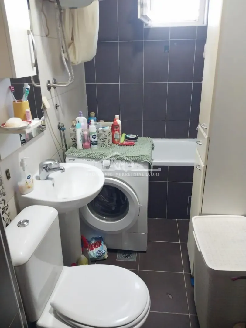 Kupatilo opremljeno sanitarijama, kadom i veš mašinom.