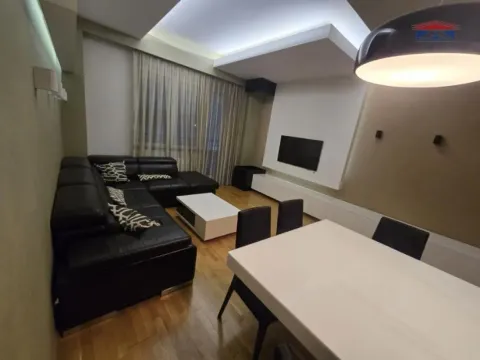Dnevna soba sa garniturom, trpezarijskim stolom i TV-om na zidu. - image 7