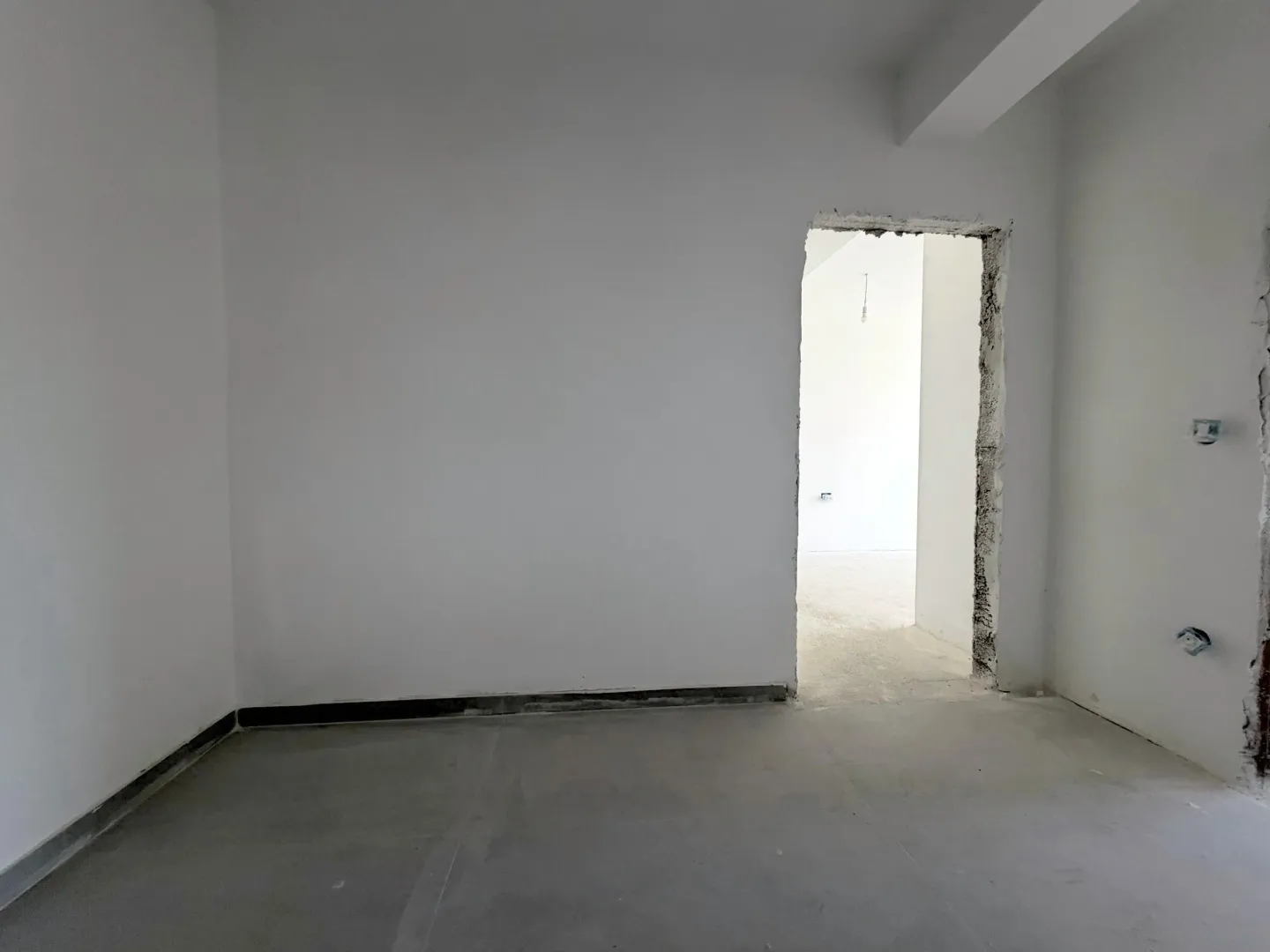 Pogled na neopremljenu prostoriju u izgradnji sa vratima.