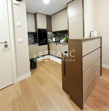 Modern kitchen with built-in appliances and dining area. - image 5