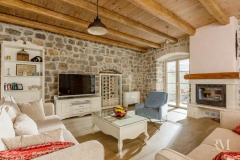 Living room with stone walls, wooden beams, and a fireplace. - image 11