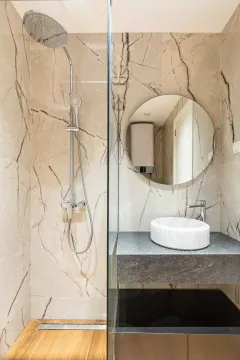 Moderno kupatilo sa tuš kabinom, okruglim ogledalom i elegantnim lavaboom. - image 24