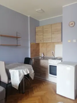 Smaller kitchen with a dining table and wooden cabinets. - image 4