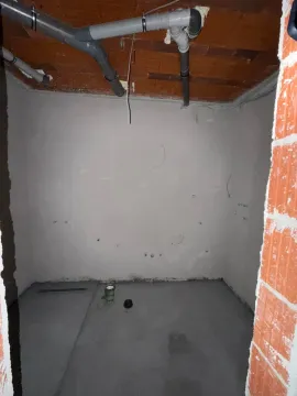 Prazna prostorija u sivoj fazi gradnje sa instalacijama na plafonu. - image 15