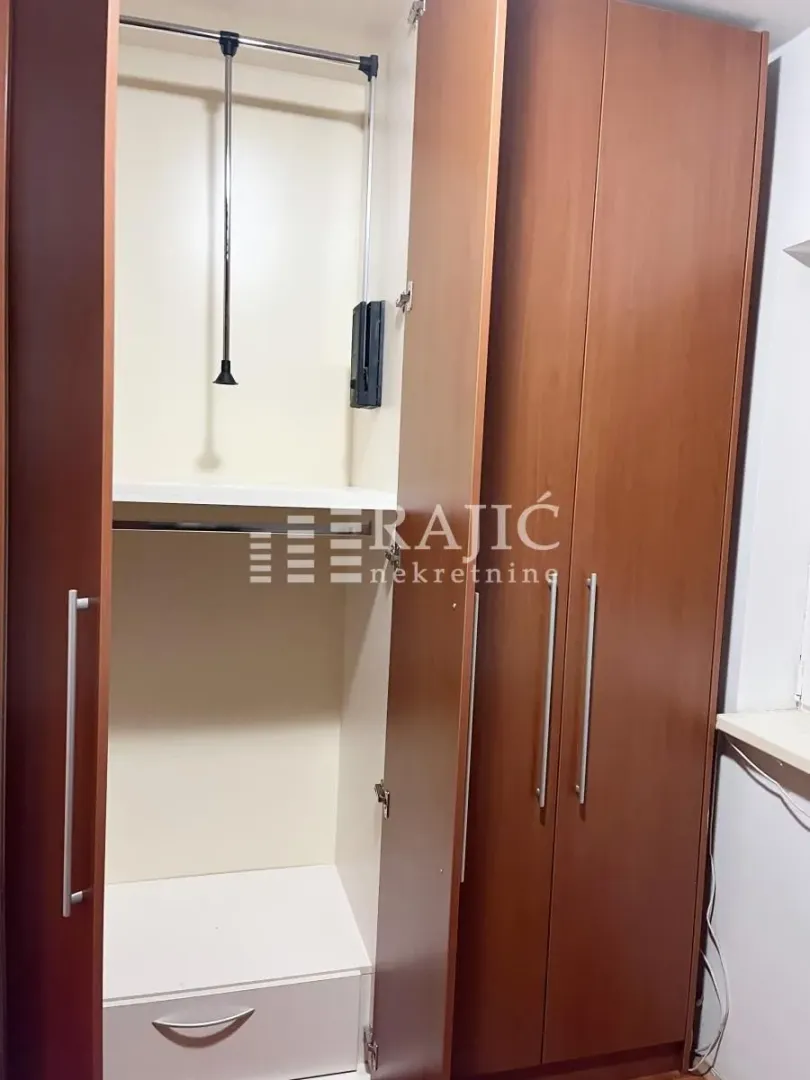 Wooden wardrobe with shelving and a hanging section.