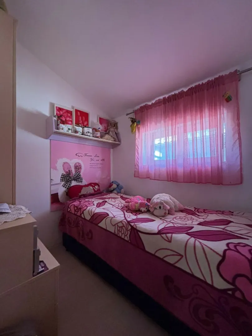 Children's bedroom with a bed and pink details.