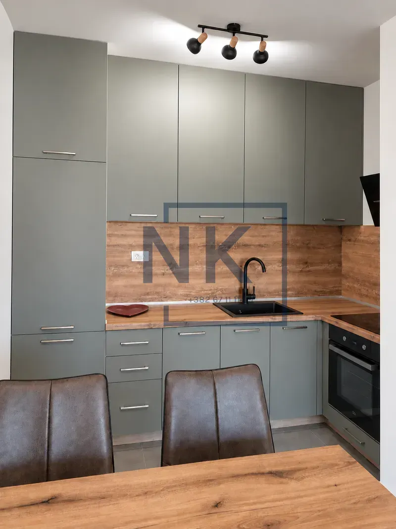 Modern kitchen with grey units and a wooden worktop.